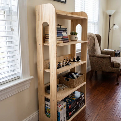 Narrow solid pine shelving unit with books, display items and storage baskets near a window