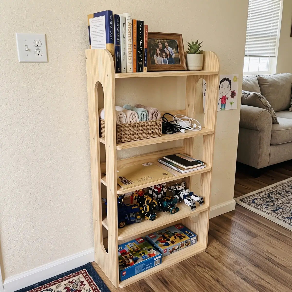 Unfinished solid pine narrow storage shelf with books, baskets and toys in a living room