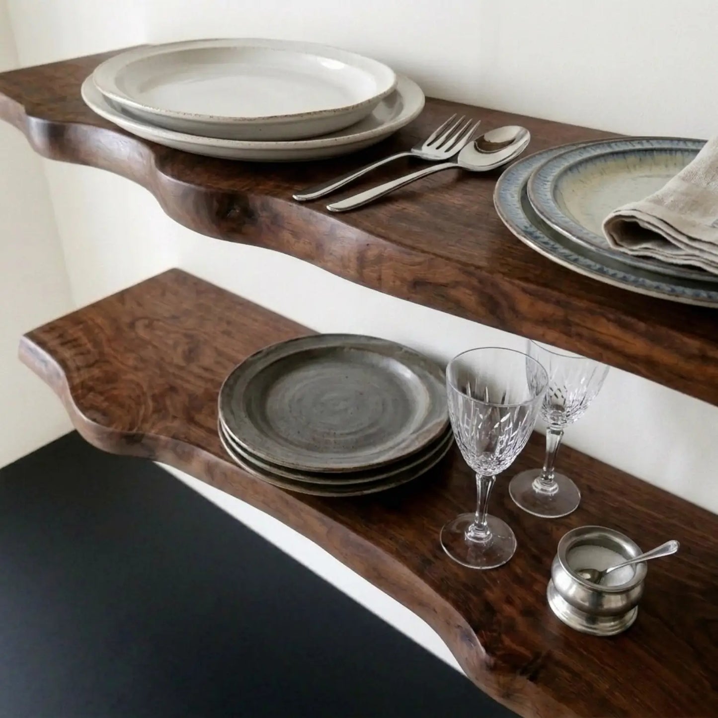 Dark walnut solid wood live edge floating shelf styled with plates and glassware, wall mounted shelf for kitchen and dining room display