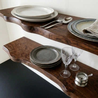 Dark walnut solid wood live edge floating shelf styled with plates and glassware, wall mounted shelf for kitchen and dining room display